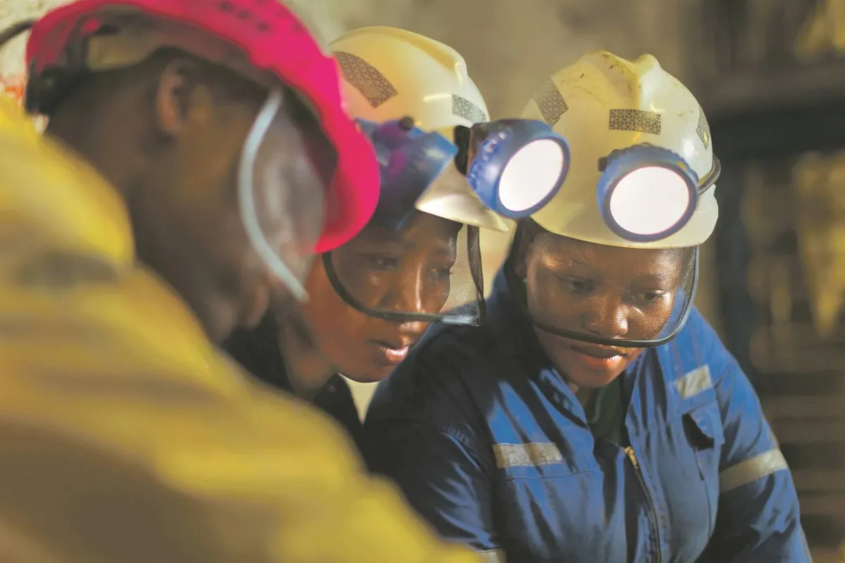 Mining worker wearing yellow hard hat and safety glasses at an industrial mining site